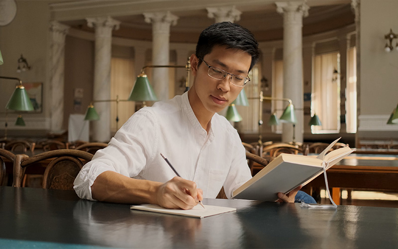 Student engaged in research at a library.